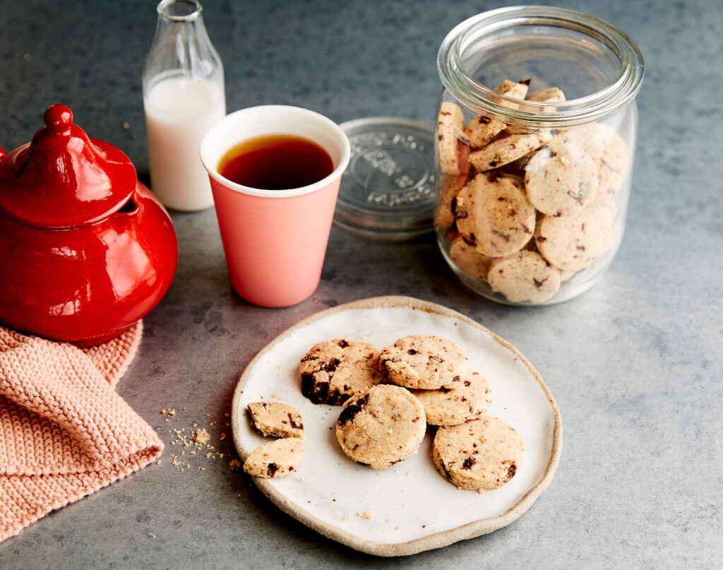 A shot from above of chop chip shortbread cookies on a plate next to a pot of coffee.