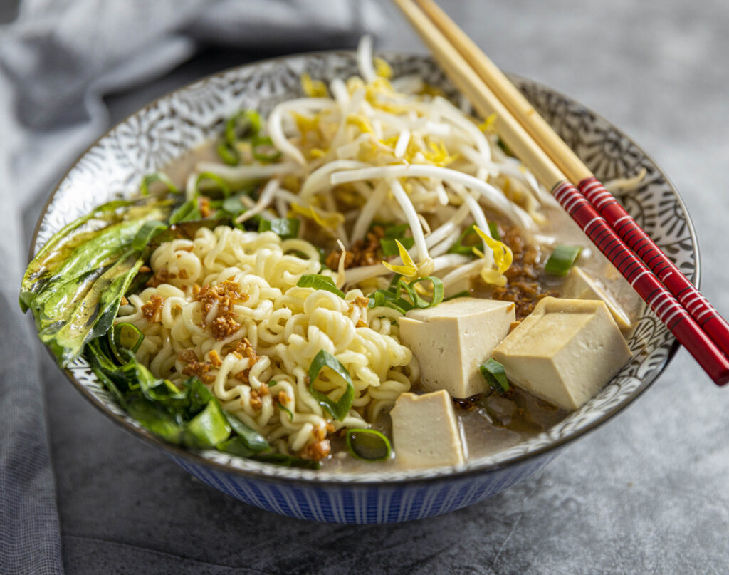 A bowl of vegan ramen with chopsticks sitting atop.