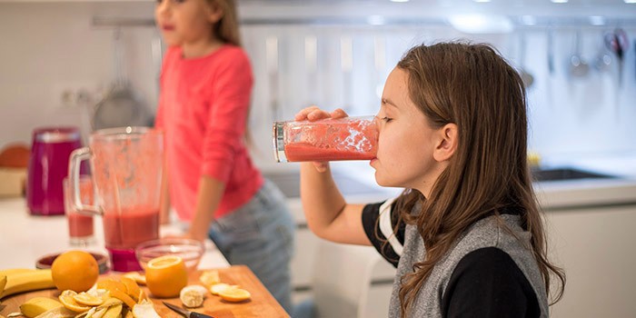 Young girl drinking a smoothie.