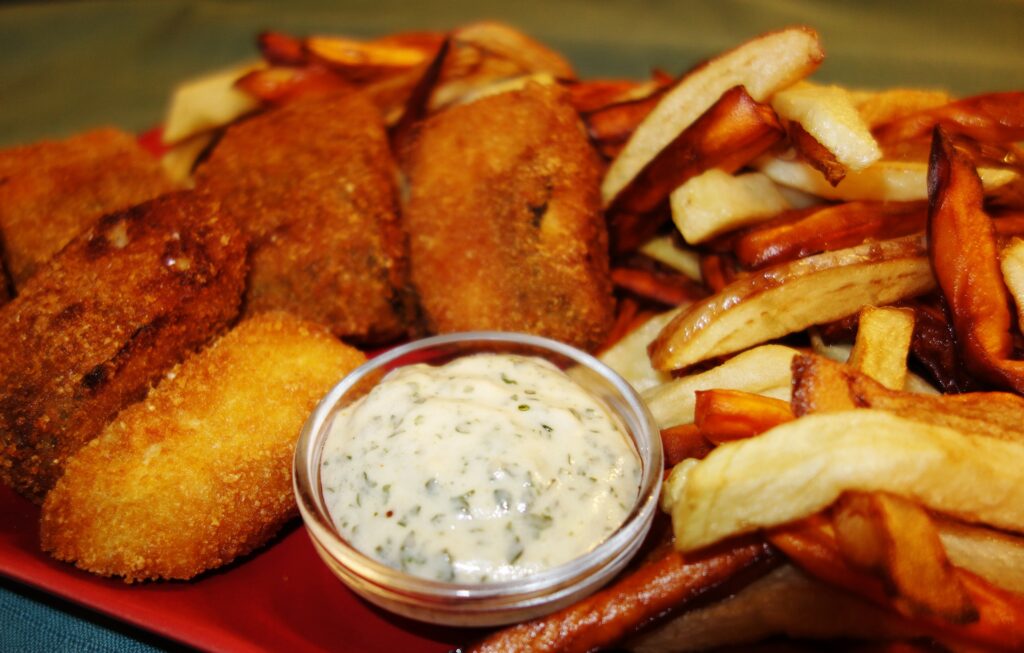 Close up image of fried vegan fish with chips and tartare sauce.