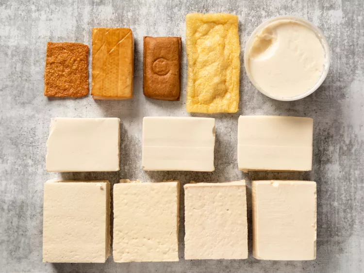 An overhead shot of different types of tofu on a benchtop.