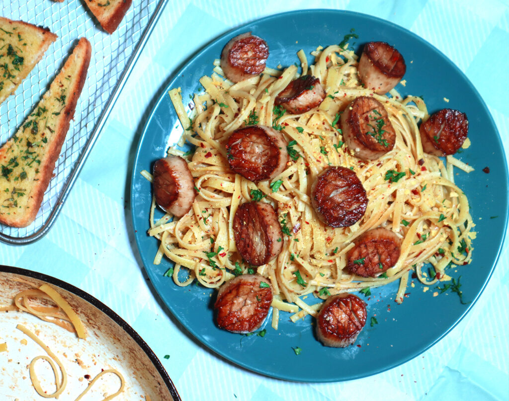 A pasta dish topped with mushroom 'scallops'.