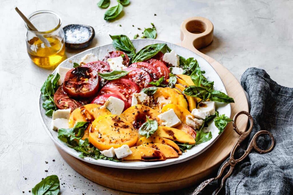 Image of colourful Caprese Salad with slices of peach.