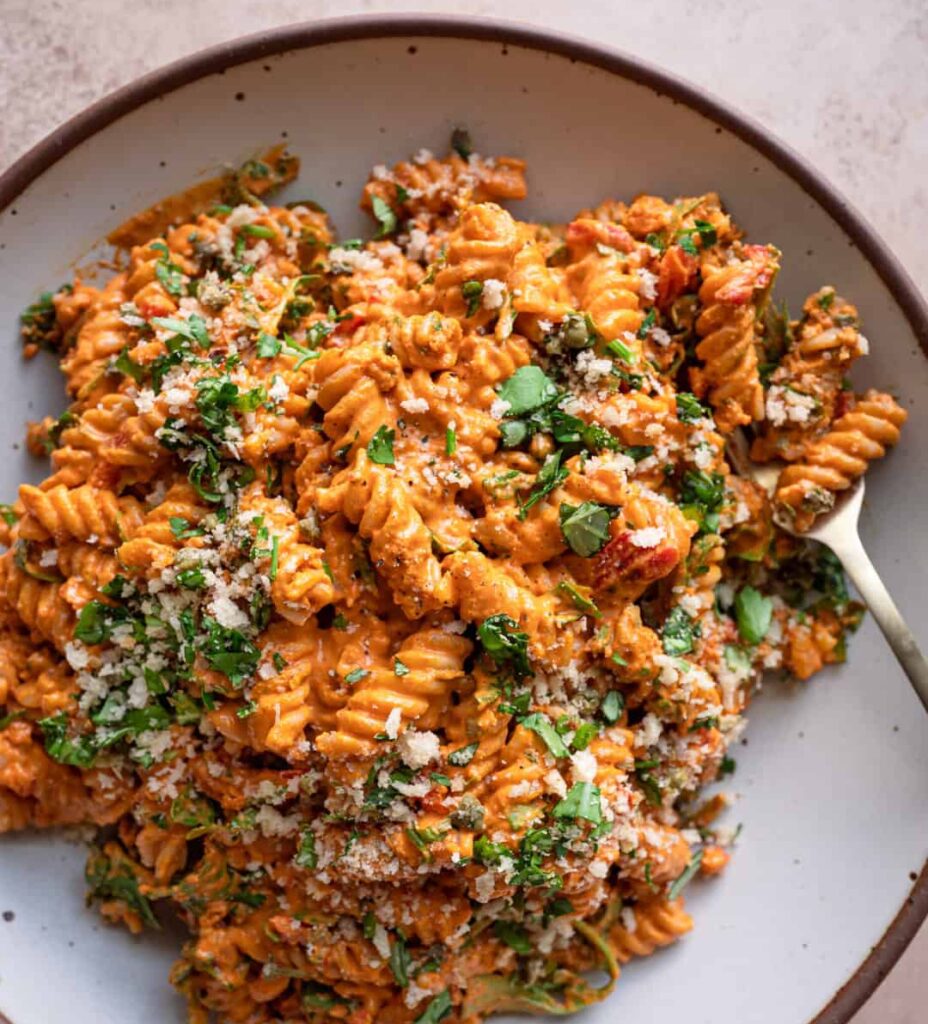 Overhead image of a red pasta salad on a plate.