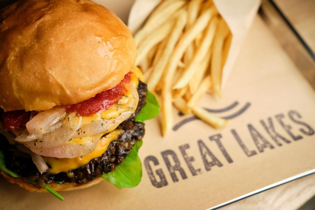 A plant-based burger and fried sitting atop a Great Lakes printed menu.