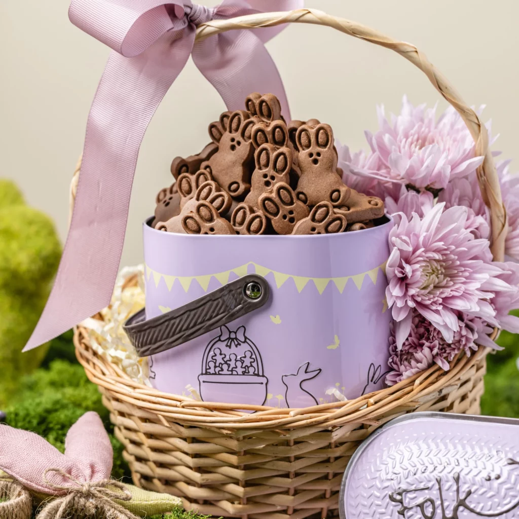 A gift basket full of mini choc gingerbread bunnies, tied with a lavender ribbon. 