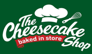 The Cheesecake Shop logo in red and white font on a forest green background.