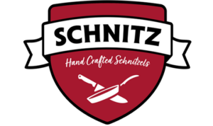 Schnitz badge logo in red, white and black on a white background.