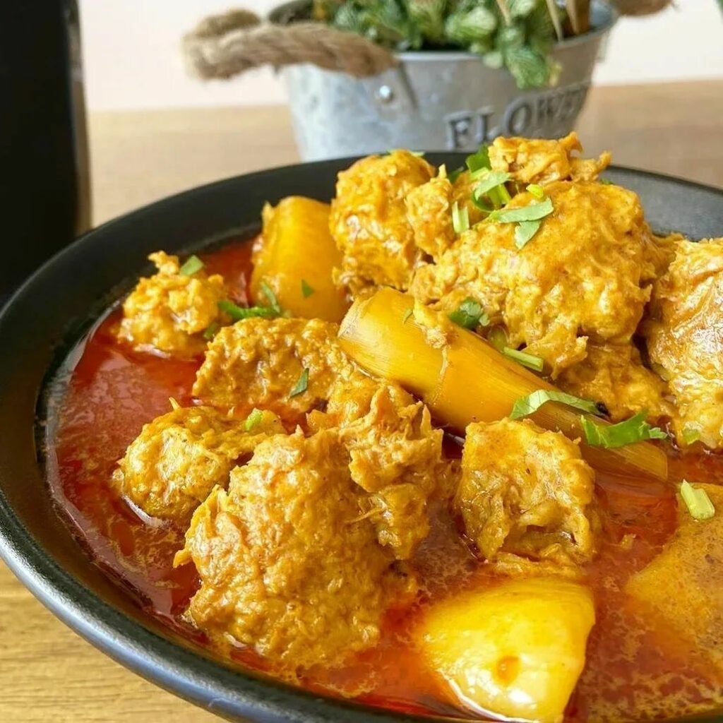 A close up of a chicken curry on a restaurant table.