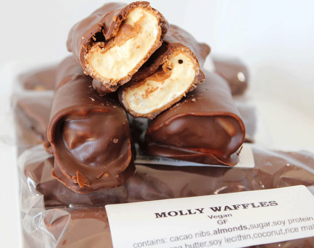 A pile of Molly Wafffle bars sit on a plate, one cut to show the wafer and marshmallow centre.