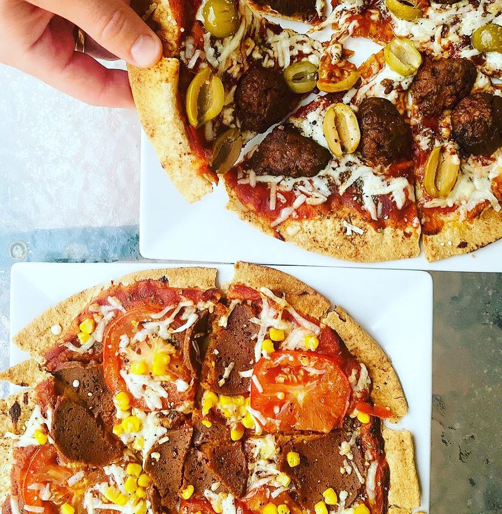 Overhead view of two pizzas topped with pepperoni slices from Suzy Spoon's Vegetarian Butcher.