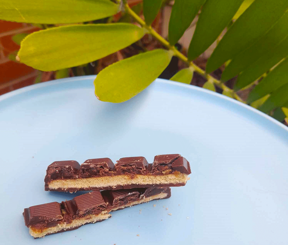 A Twicks bar cut lengthways shows the cross section of shortbread biscuit and chewy caramel.