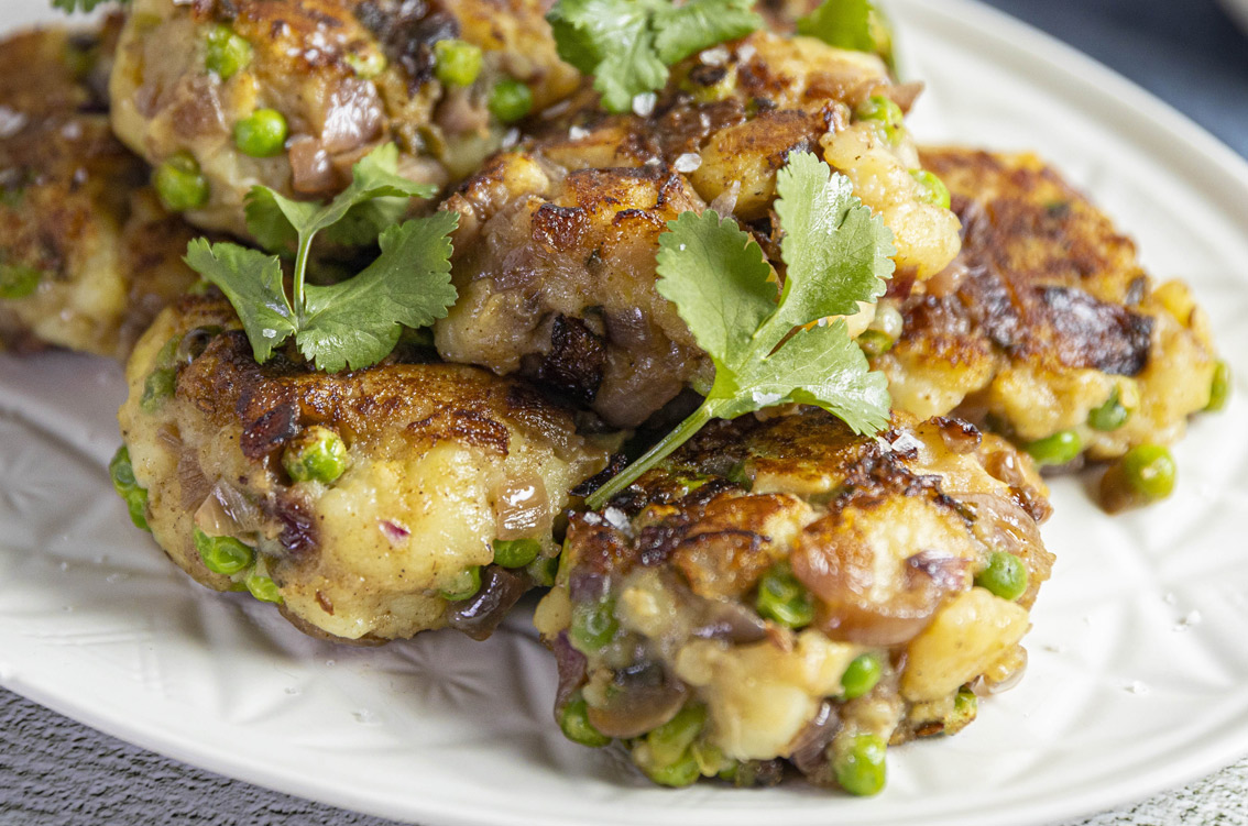 spiced potatoes patties on plate with herbs on top