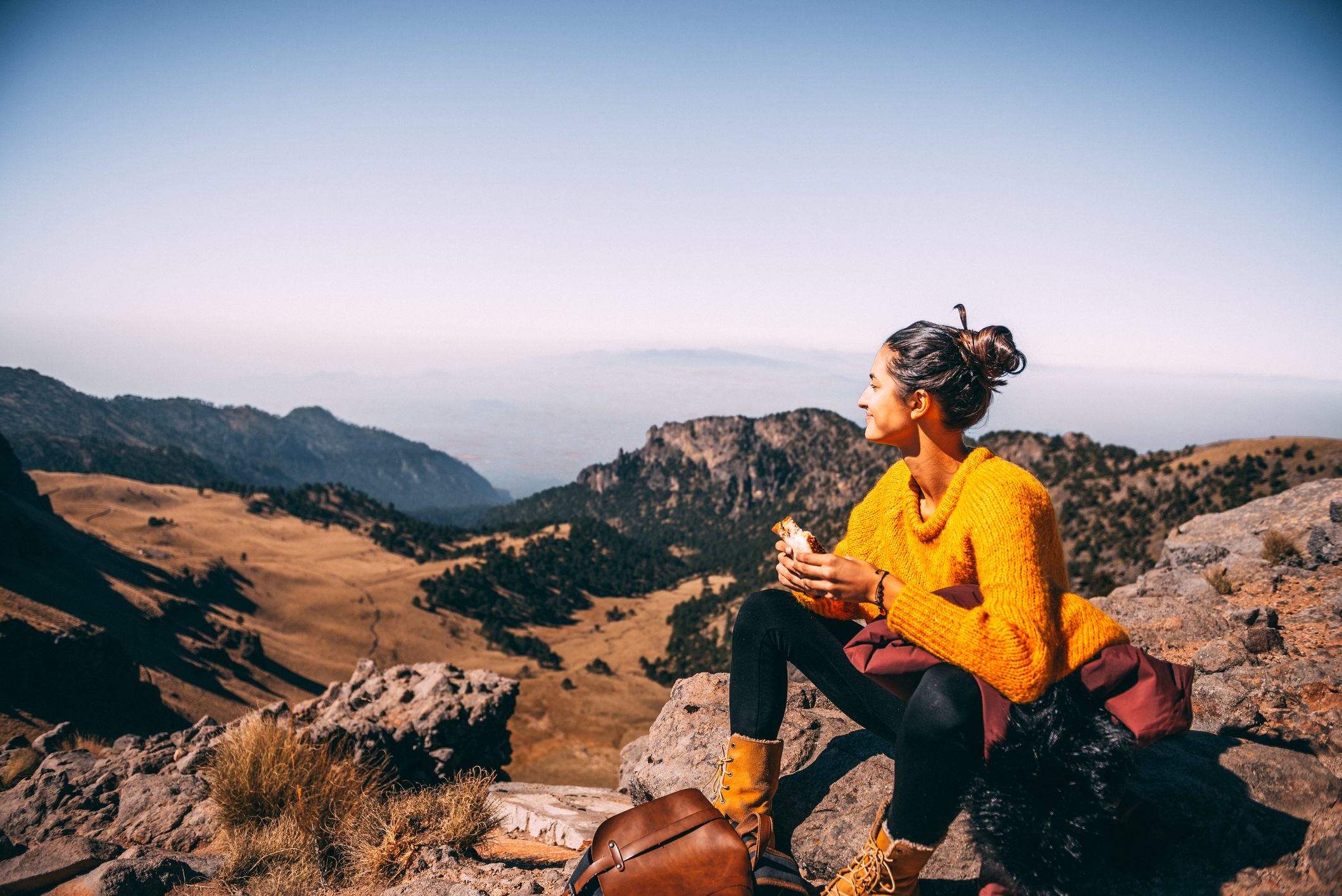 Tired Latin woman making a launch break. She is hiking at Popocatepetl volcano in Mexico