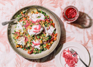 Overhead image of colourful Farro Salad on pink background.