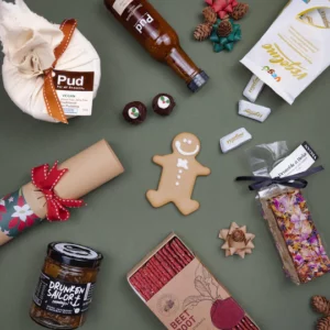 An overhead image of vegan seasonal items, including gingerbread, chocolates, pudding, and dessert sauces.