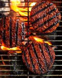 Overhead shot of plant-based burgers on a grill, cooked to perfection..