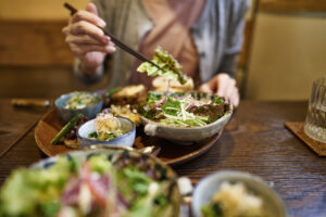 Woman eating a vegan plate of Japanese cuisine.